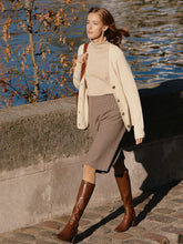 Woman wearing cardigan and woolen skirt and leather boots